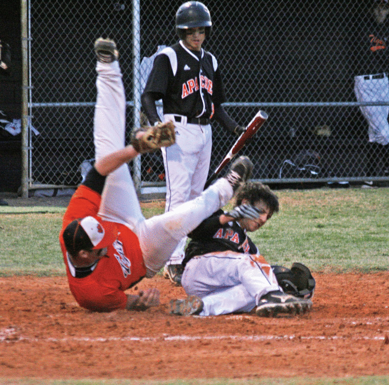 Dalton Kuntschik (right) of Gonzales bowls over the Smithville pitcher who was covering home plate after a passed ball allowed another Apache run to score. Aaron Gayton (background) was the batter when the ball got away from the catcher.