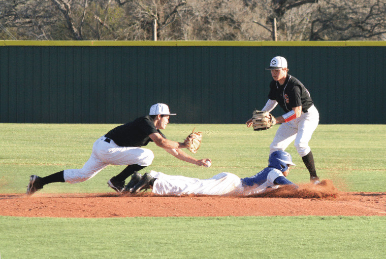 Cole Hybner (left with ball in hand) of St. Paul dives to tag out a Yoakum runner during a rundown that ended at second base. The Cardinals beat the Bulldogs, 7-6.