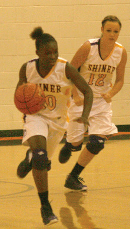 Shiner guard LaNeshia Hunt, left, dribbles downcourt as teammate Meagan Chumchal, right, trails behind her during the Lady Comanches’ 74-26 rout of Hawkins Thursday at Shiner High School.