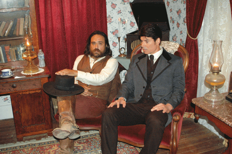 Justin Meeks (left) and Benjamin Dane prepare for a scene in the living room of the historic Muenzler House located on the grounds of the Pioneer Village Living History Center in Gonzales, Texas.