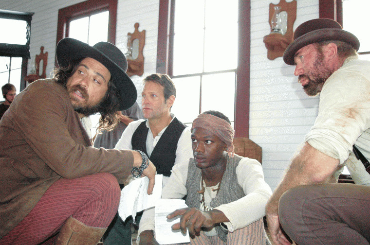 From left, co-director Justin Meeks, Tom Lagleder, Deon Lucas and Greg Kelly discuss a scene for "Red on Yella, Kill a Fella" at the Pioneer Village Living History Center in Gonzales, Texas.