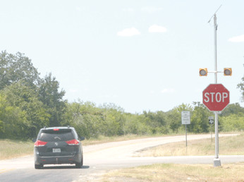 A motorist safely regards new beacon lights by coming to a complete stop at the intersection of Highway 80 and FM 466.