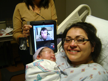 Utilizing the Skype® computer software application for an
Internet video call from a U.S. military base in Afghanistan to
Texas, Sgt. Joshua Sanchez was able to witness the birth of his
first child last week. Mom Monica Leal and baby Bradyn were joined
by Dad via an iPad (held, at left, by Joshua’s mother, Aida
Rodriguez).