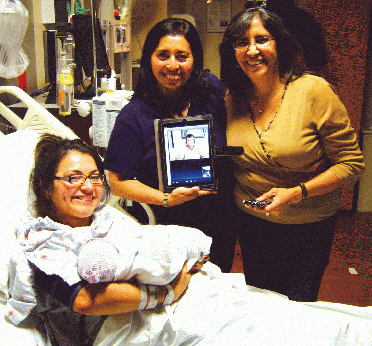 Although serving in the Marine Corps in Afghanistan, Dad Joshua
Sanchez (via Skype) got to witness the birth of his son, Bradyn. In
a quiet moment after the Big Event, Mom Monica Leal (holding
Bradyn), Dad (on an iPad) and grandmothers Mary Jane Leal (left)
and Aida Rodriguez shared smiles.
