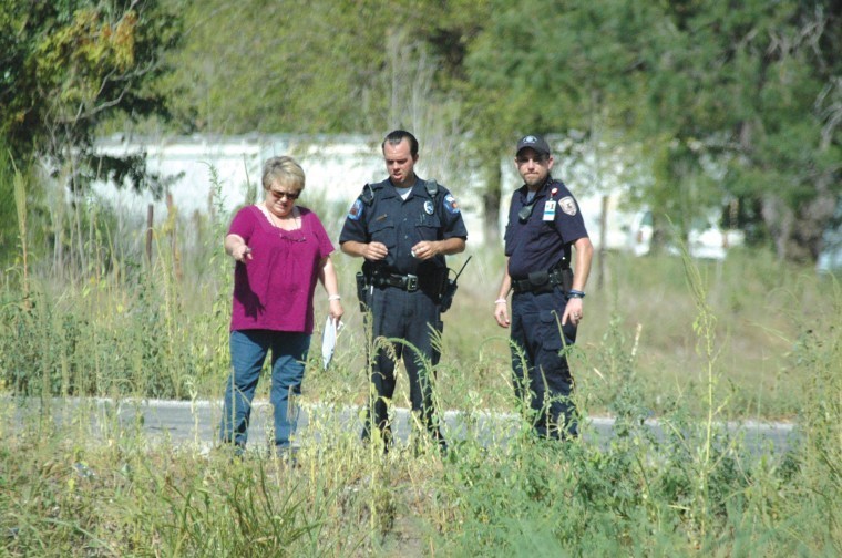 Gonzales County Precinct 1 Justice of the Peace Deidra Voigt
confers with Gonzales police officers at the scene where a body was
found Tuesday afternoon. The unidentified person was found lying in
a ditch at the intersection of Badger and Henry.