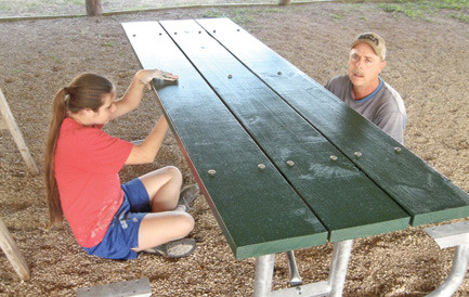 Hannah and her dad, Mark, adjusting the bolts on a new table