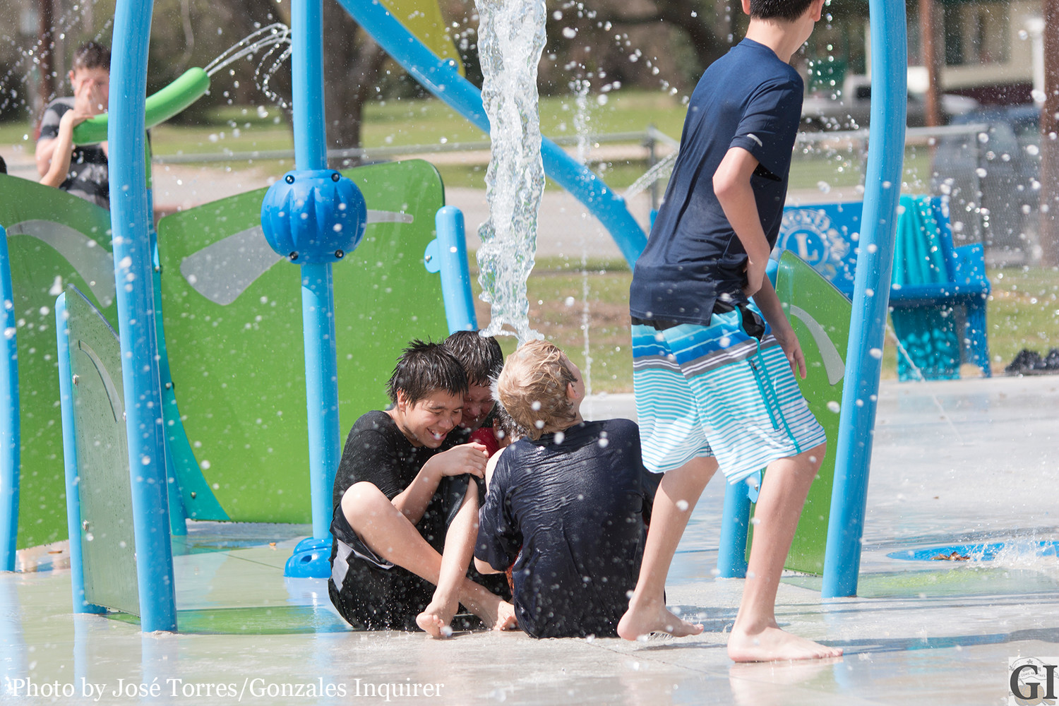 Water comes crashing down Gonzales children taking advantage of the weather Saturday near noon at the splash pad.