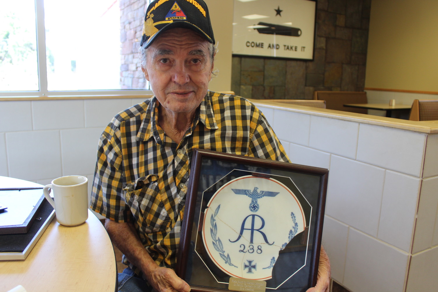 Maness Johnston holds the Nazi Luftwaffe plate he discovered in a dry creek bed in West Berlin.