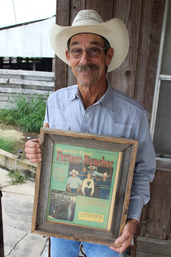 David Shelton holds a picture of the story the Gonzales Inquirer put together announcing his purchase of the Gonzales Livestock Auction House in July, 1999.
