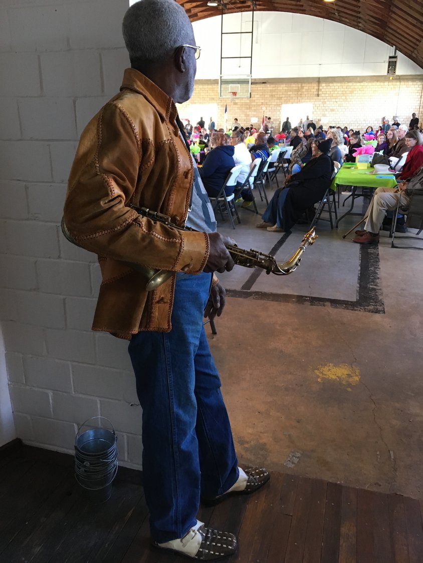 Local saxophonist and community elder O.S. Grant waits for his turn to serenade the crowd at the Edwards Community Center.