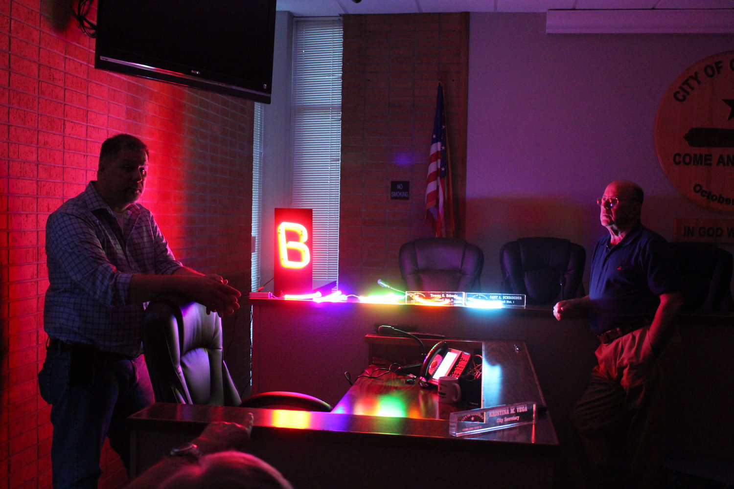 Allen Sawyer (left), National Signs representative, demonstrates two LED options to be used for the Lynn Theater sign and marquee to Tommy Cox (right) and the rest of the present GEDC board.
