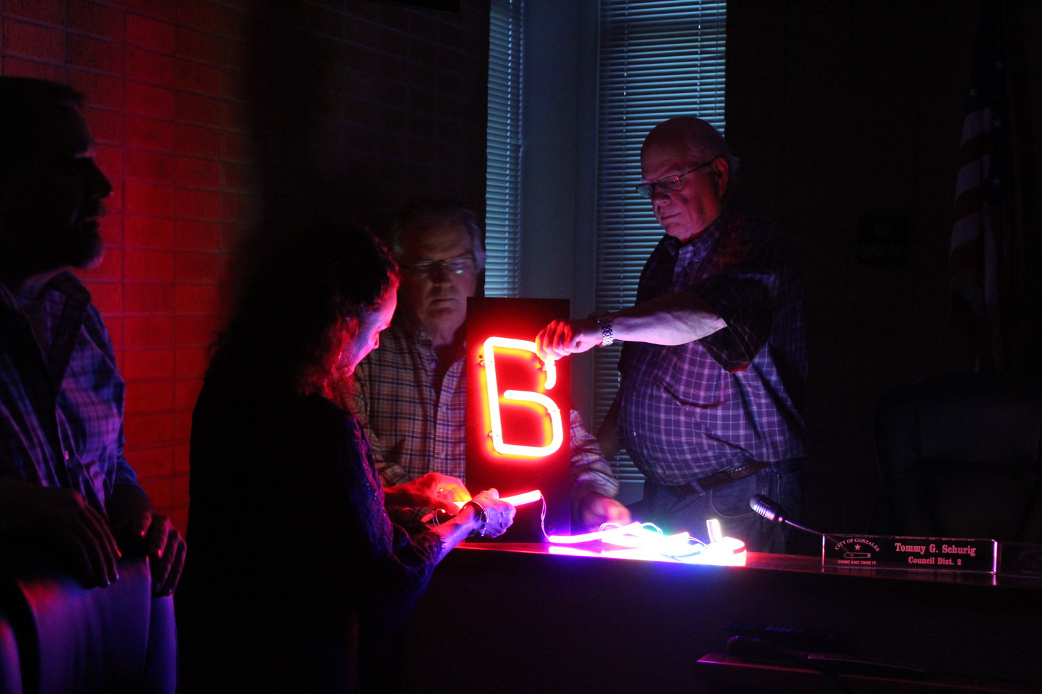 Board Member Dan Blakemore (right) feels the firm LED display as GEDC President/CEO Genora Young (second to left) and Board Member Steve Sucher (center) investigate the malleable string lights. Allen Sawyer (far left), National Signs representative, brought two LED displays for the GEDC to compare. Ultimately, GEDC went with the string lights.