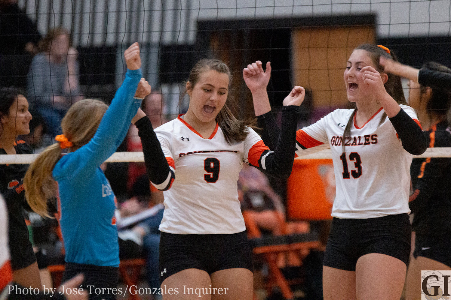 Kristin Baker (9) and Hayley Sample (13) celebrate a kill with the team.