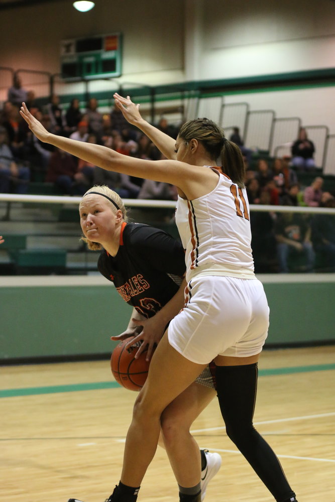 Devon Williams (23) maneuvers her way around Beeville’s star center Kamaria Gipson (11). Williams ended the night with a team-leading 15 points.
