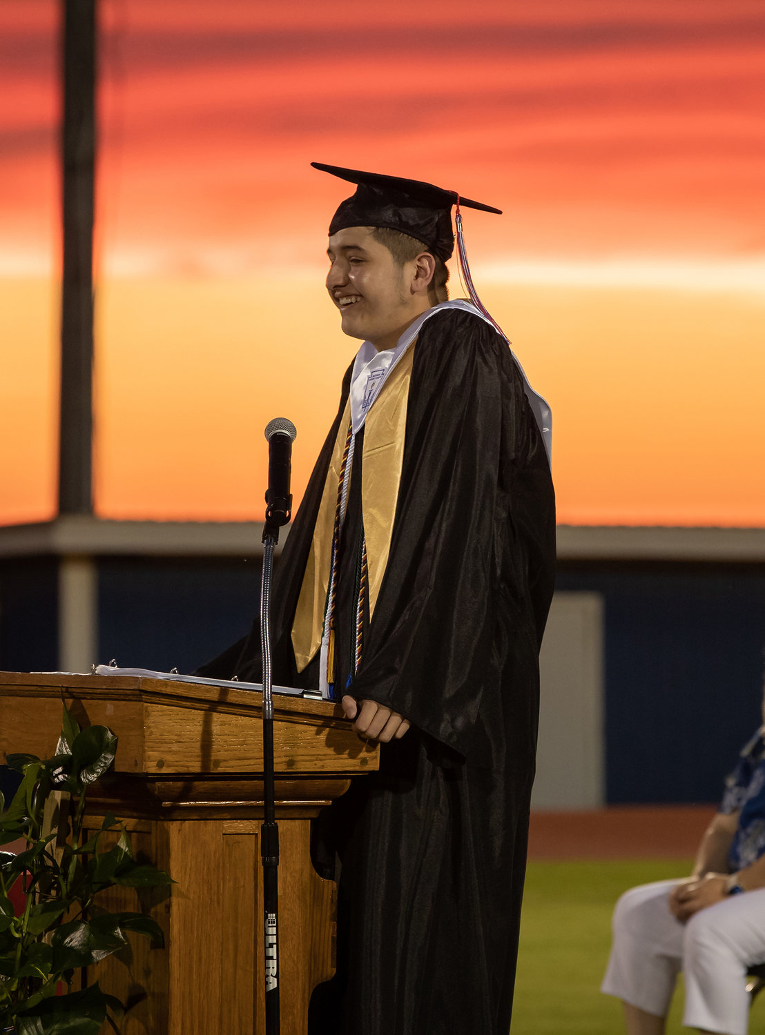 The setting sun made the perfect backdrop for the graduation ceremony Friday evening for the 71 graduates of Nixon-Smiley. Pictured is Jose Gonzalez addressing fellow classmates.