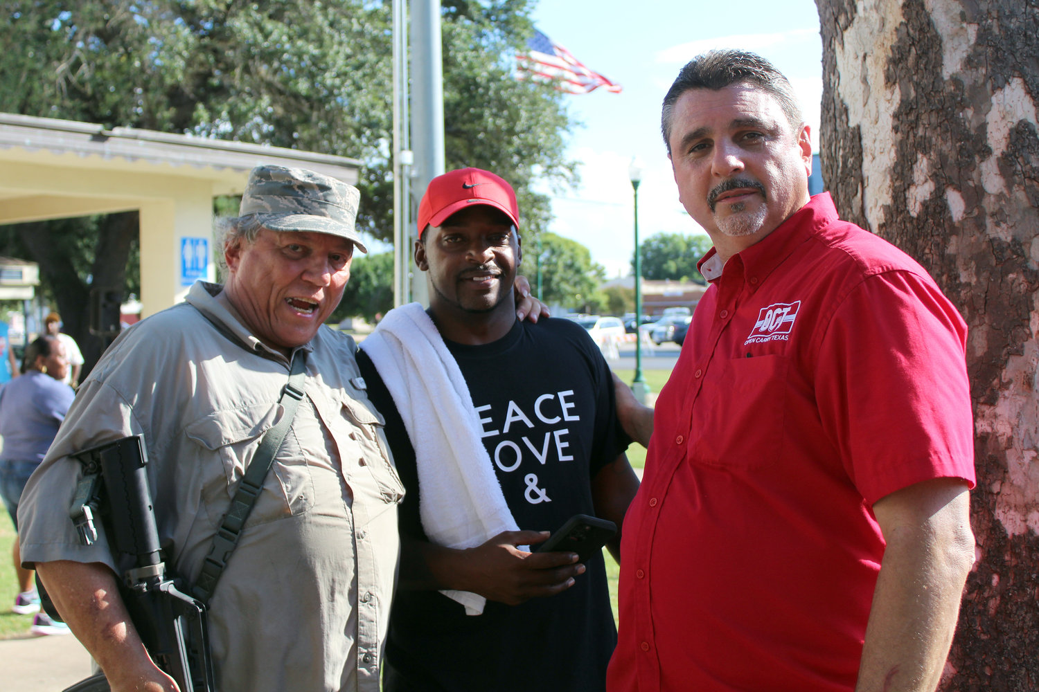 Mark Gurgevich, left, and David Amad, right, representing This is Texas Freedom Force and Open Cary Texas, meet with Gonzales Juneteenth co-coordinator Joe White prior to the start of the Juneteenth celebration in Confederate Square.