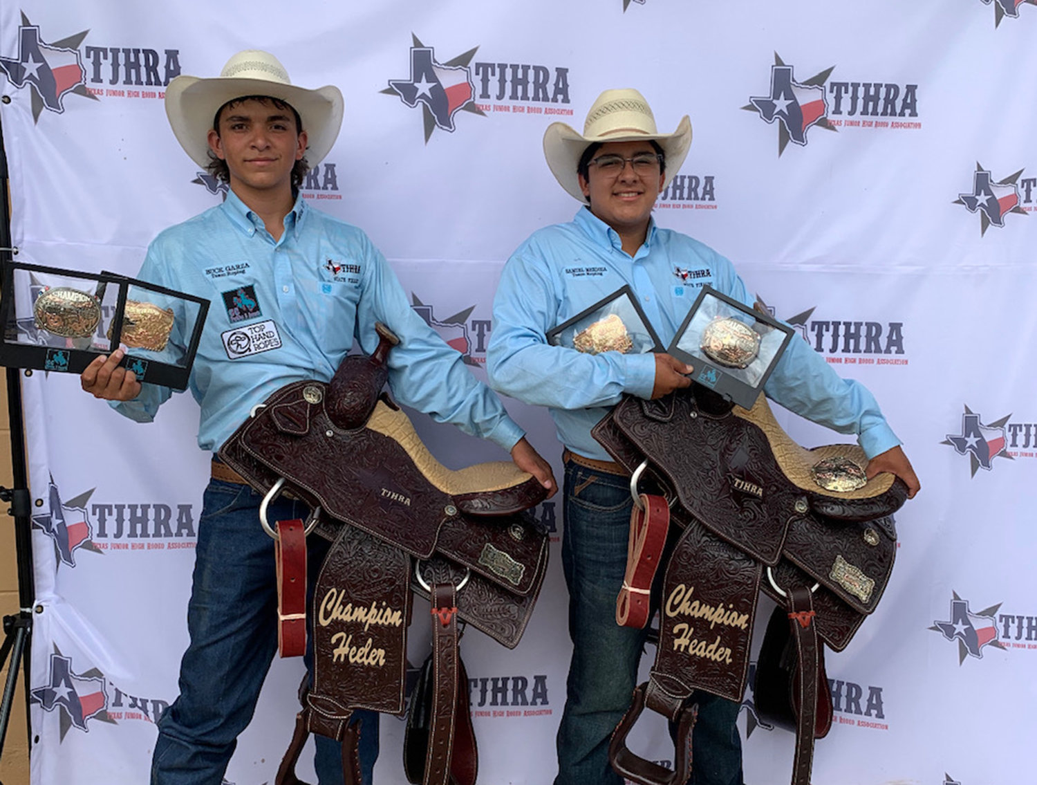 Team ropers Buck Garza (left) and his teammate Samuel Mendoza of Carrizo Springs proudly celebrate their victory at the TJHRA finals last Friday.