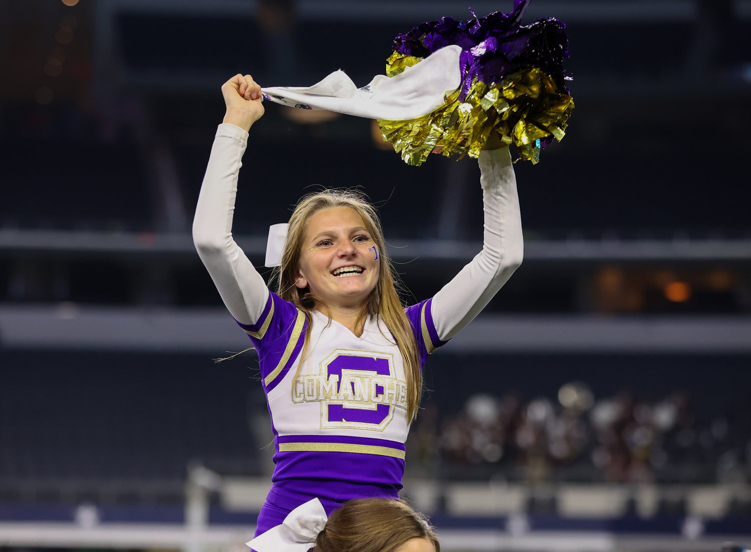A Shiner Comanches cheerleader during the Class 2A Division I state football championship game between Shiner and Hawley on December 15, 2021 in Arlington, Texas.