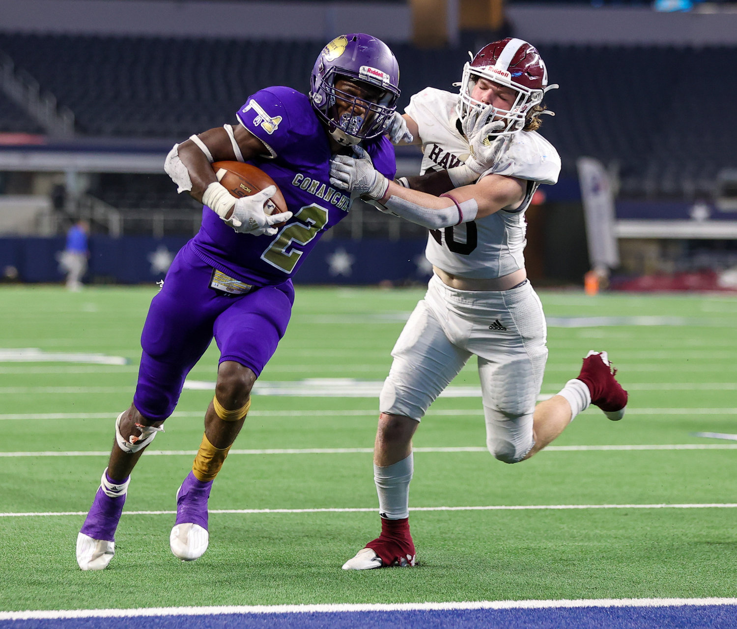 Shiner Comanches junior Dalton Brooks (2) fends off Hawley Bearcats sophomore Westyn Balch (20) on a touchdown carry during the Class 2A Division I state football championship game between Shiner and Hawley on December 15, 2021 in Arlington, Texas.