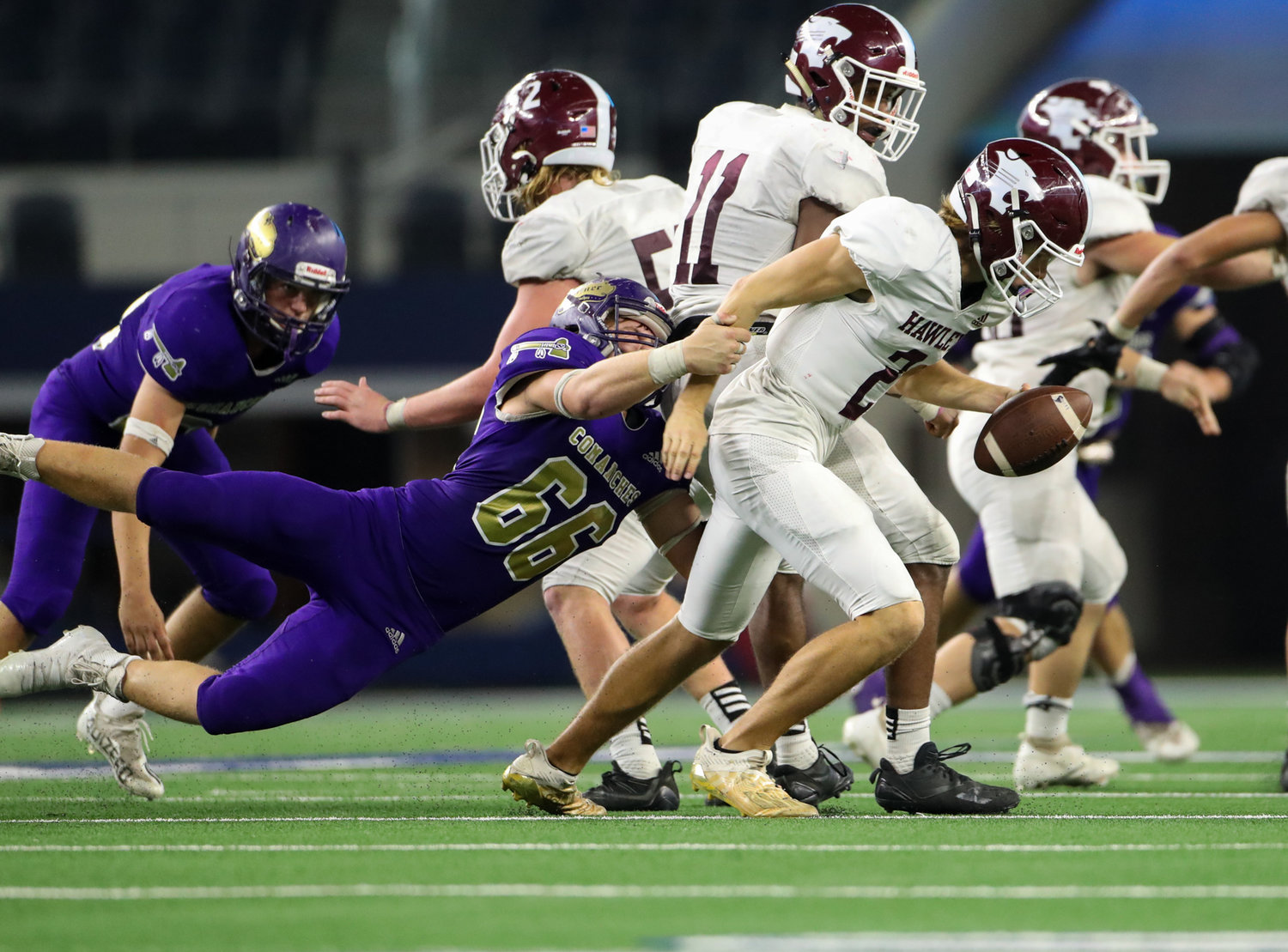 Shiner Comanches junior Dalton Patton (66) grabs onto Hawley Bearcats junior Rodey Hooper (2) in the backfield during the Class 2A Division I state football championship game between Shiner and Hawley on December 15, 2021 in Arlington, Texas.