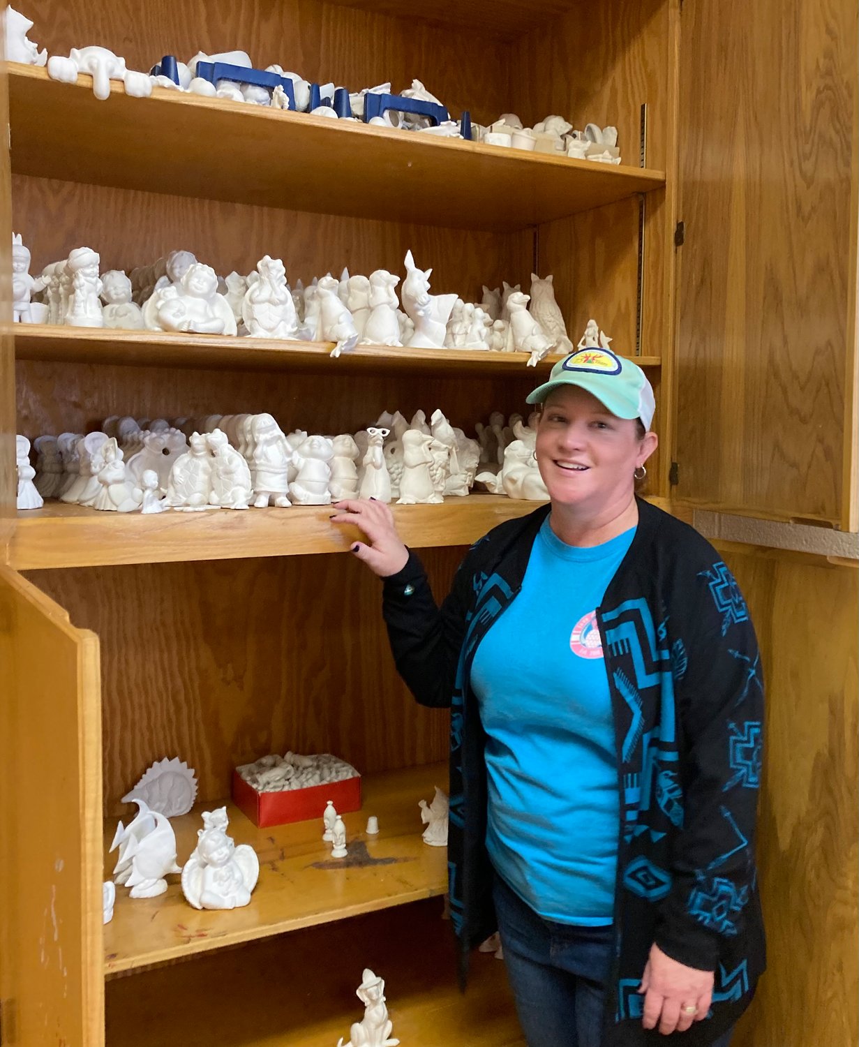 Loretta Shirley shows off a craft cabinet where ceramics are stored for the campers.