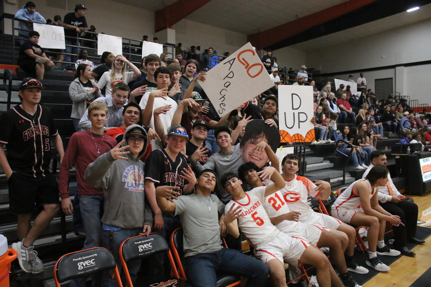Gonzales High School students join the Apache bench in holding up signs and flashing hand signals just before the third period begins during the Tuesday, Feb. 8, game against Pleasanton. Unfortunately, their spirited hijinks could not prevent the Eagles from winning the game, 62-44.