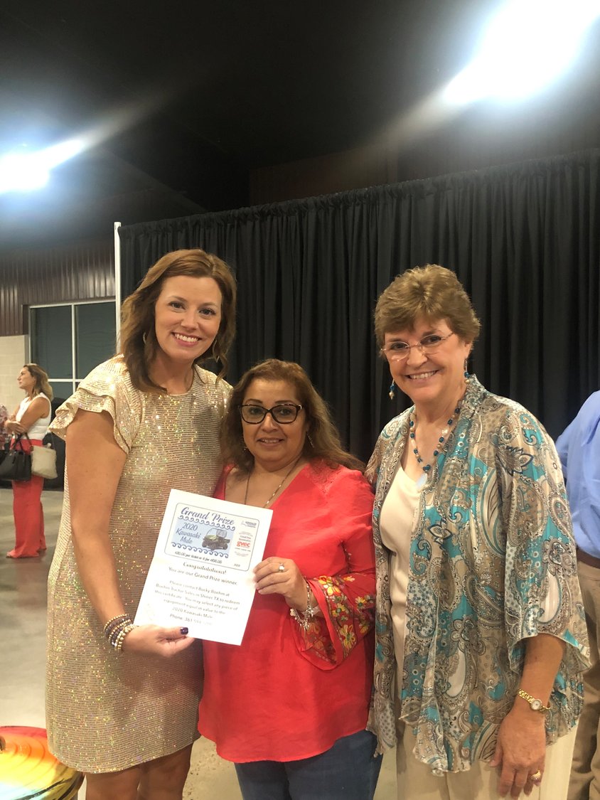 GHS marketing director Holly Danz, left, and GHS Foundation president Carolyn Orts, right, present a gift certificate from GVEC for the purchase of a Kawasaki Mule to Sandra Martinez during the 5F Gala at JB Wells Expo Center on Saturday, Sept. 17.
