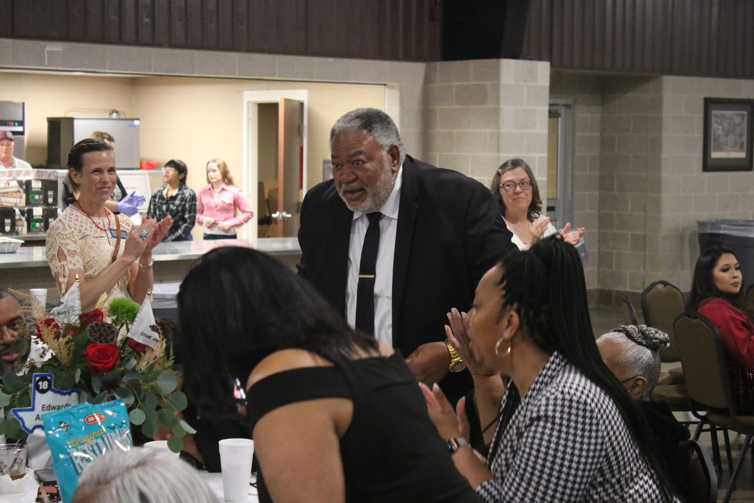 Chamber executive director Melissa Henderson, left, applauds Edwards Association president David Tucy, who stands after being named the Community Service Award winner. Tucy quoted MLK in describing how anyone can be called to service.
