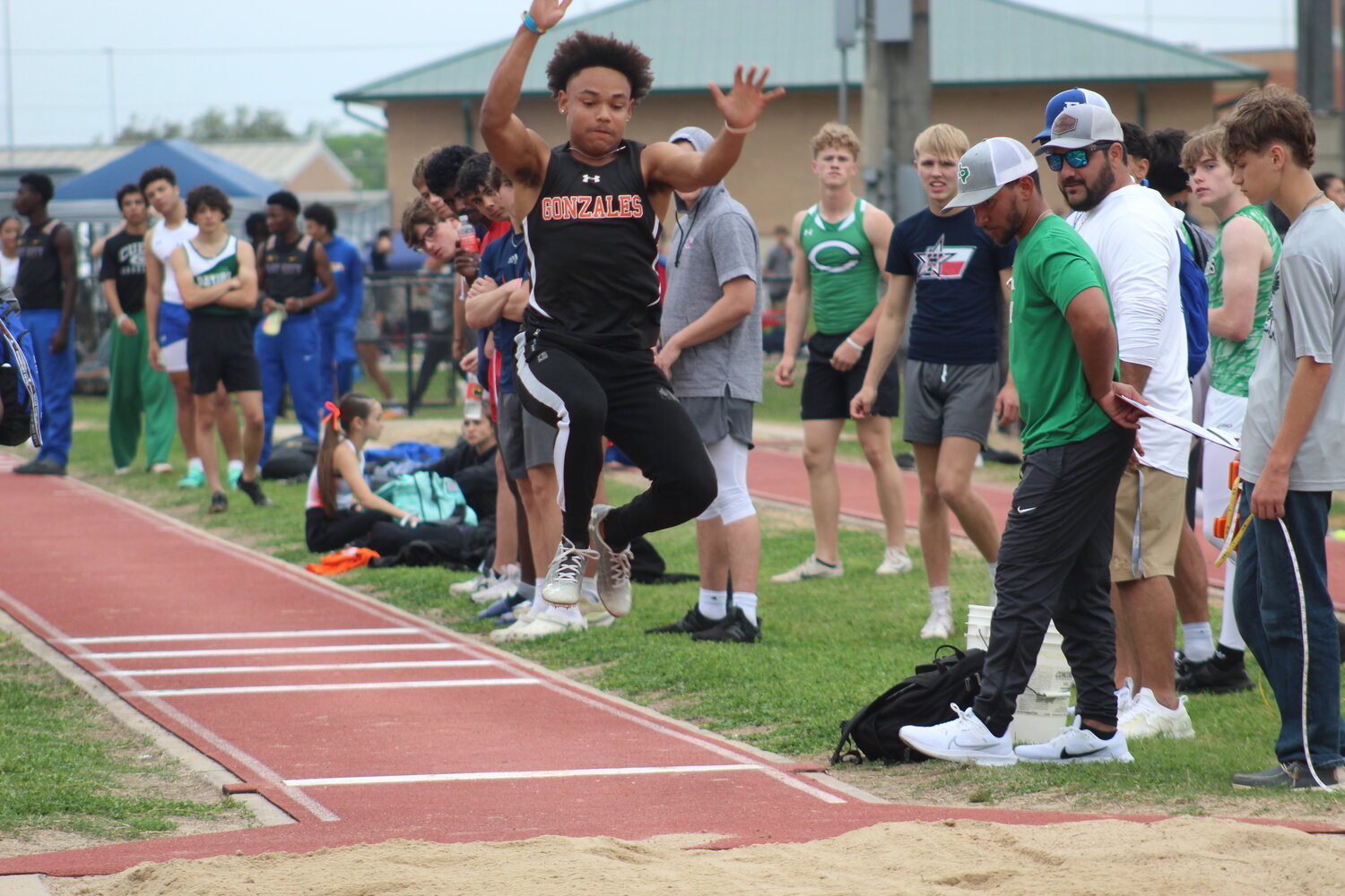 Apaches Daevien Pitts jumps in the air for the long jump competition at the Cuero track meet Thursday, March 7.