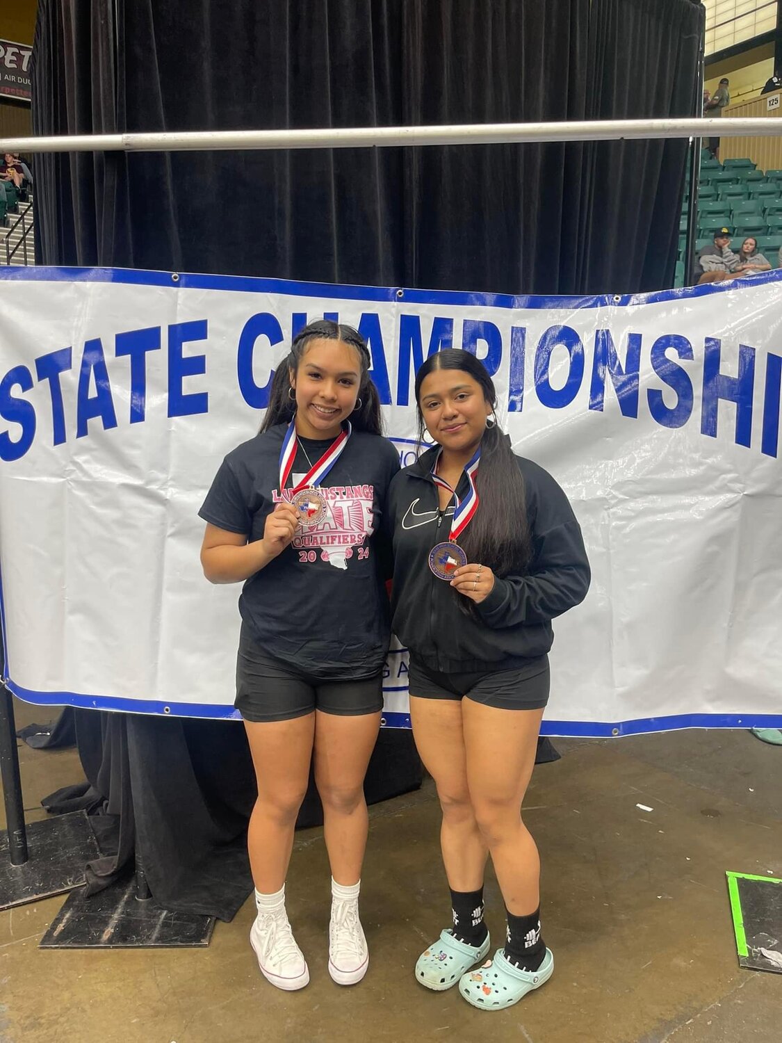 (From left) Ashly Garcia and Zulema Rodriguez hold their medals from the THSWPA state powerlifting meet Thursday, March 14. Garcia finished third in state and Rodriguez took home fourth.
