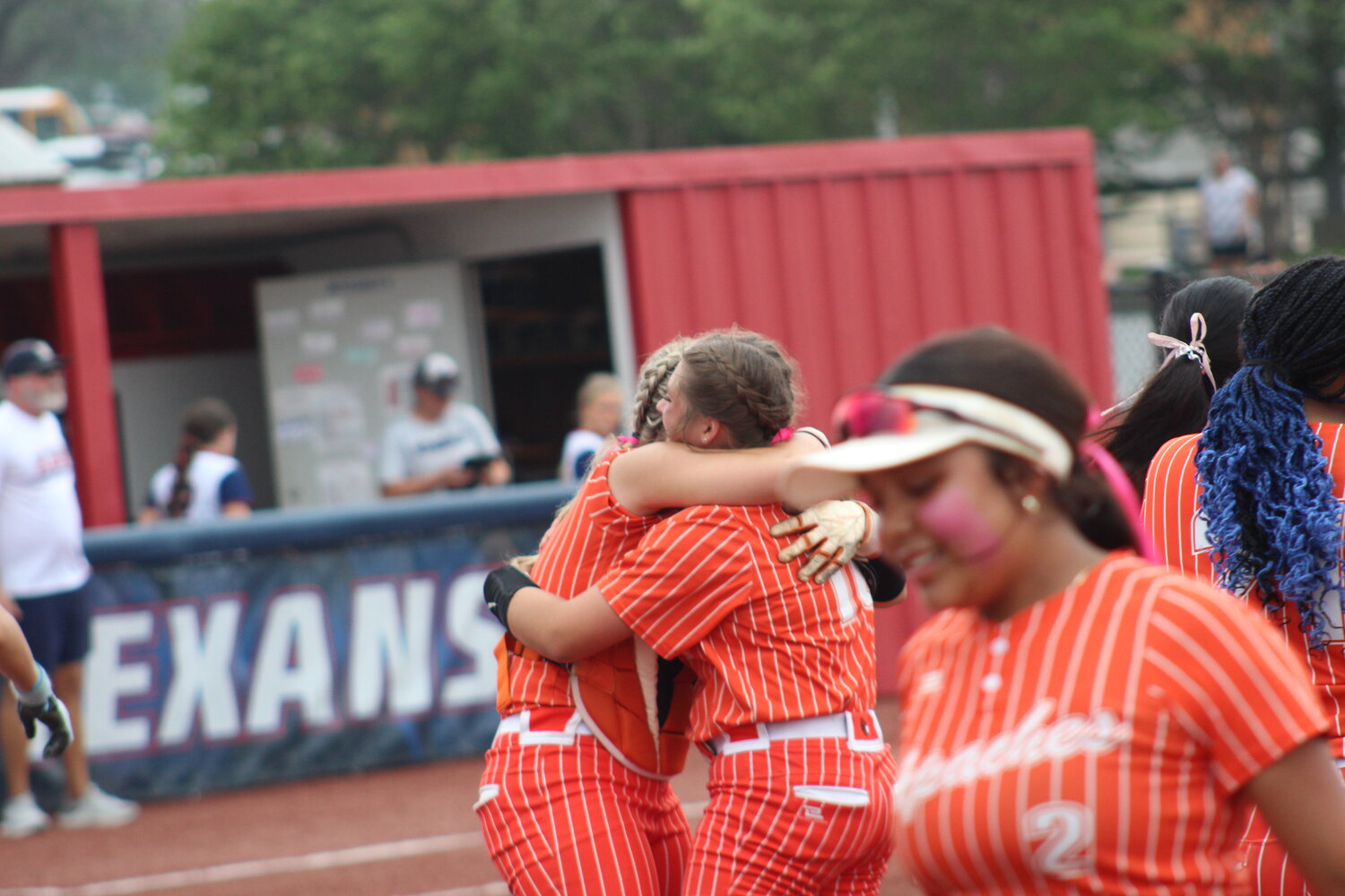 Lady Apaches freshman pitcher Dixie Rae Lester (10) hugs senior catcher Sydney McCray (3) in celebration of Gonzales first bi-district title since 2005