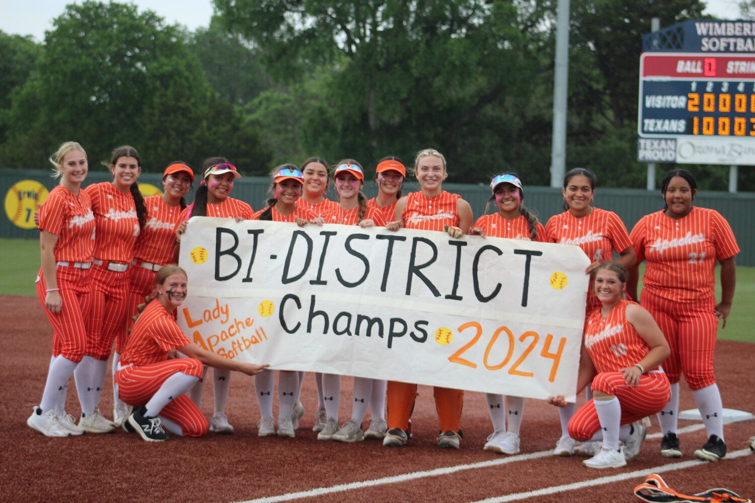 The Gonzales Lady Apaches hold their bi-district championship banner after beating Wimberley in three games Saturday, April 27.