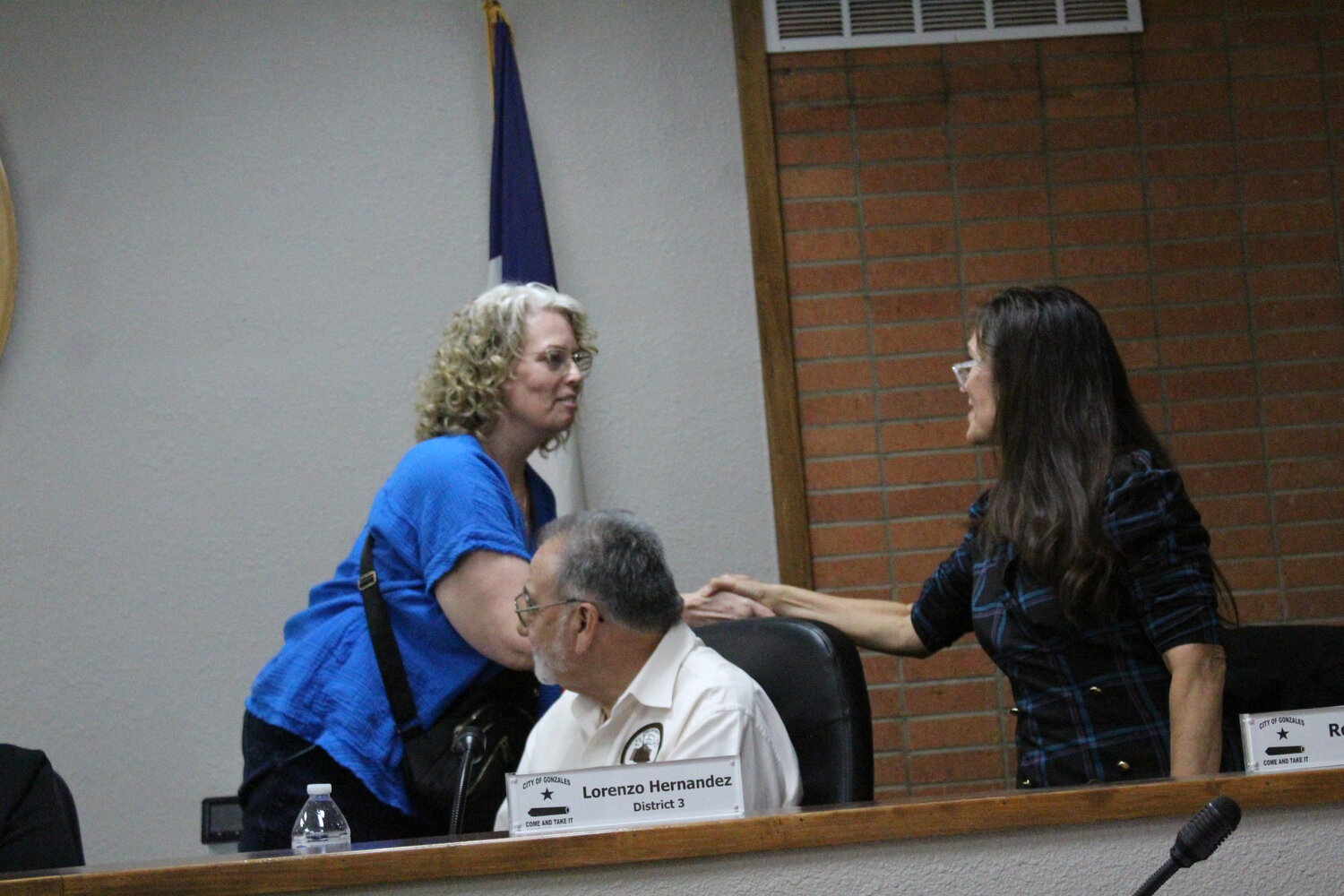 Former Gonzales Councilwoman Sherri Koepp, of District 2, shakes councilwoman Ronda Miller’s hand  as she leaves the council Tuesday, May 14.