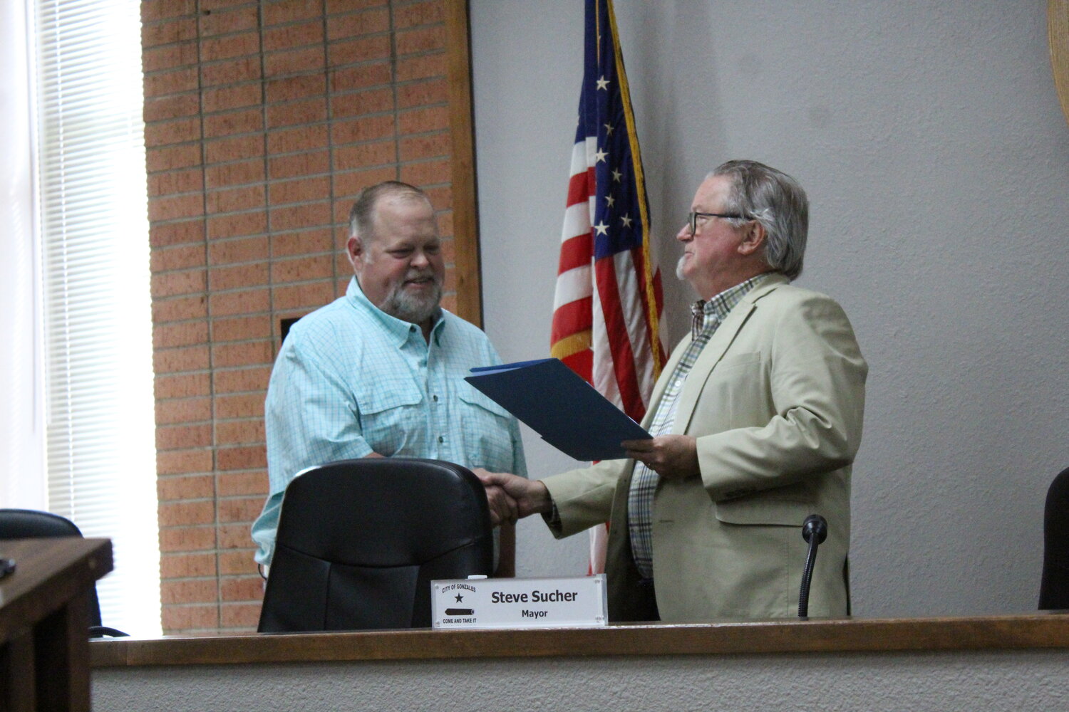 Councilman Joseph Kridler, of District 1, shakes Mayor Steve Sucher’s hand as he is sworn back onto the Gonzales City Council for another term unopposed Tuesday, May 14