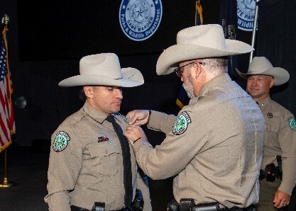 Colonel Chad Jones, right, pins a badge on Warden Brzozowski.