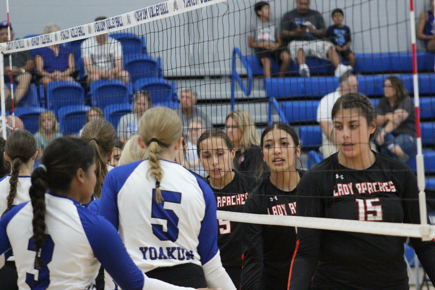 The Gonzales Lady Apaches and Yoakum Lady Bulldogs congratulate each other at the net for the conclusion of the first game of the dual match.