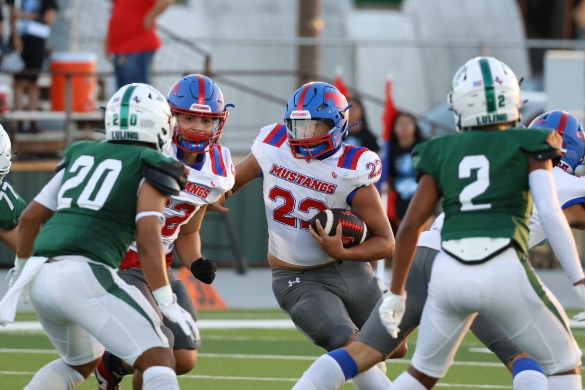 Mustangs running back Julian Amaya (22) runs in the middle of Luling defenders in the season opener of the 2024 Texas High School Football season Friday, Aug. 30.