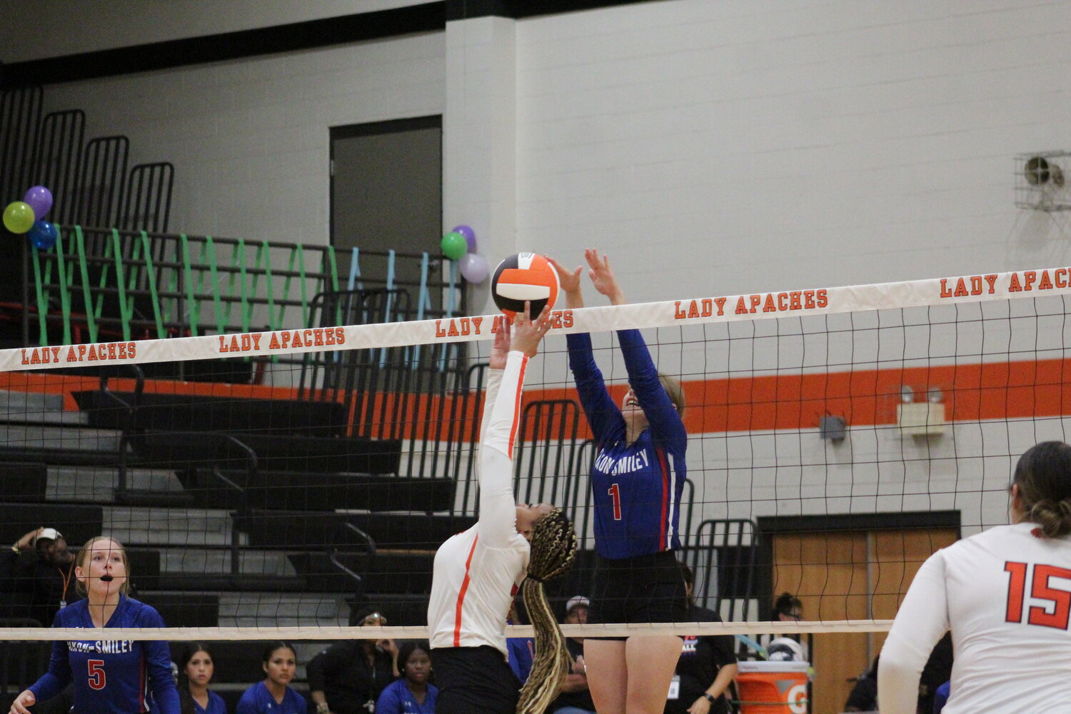 Lady Mustangs senior Brooke Crisp (1) jumps for a block against Gonzales sophomore Shykayden Clack (7) in the inter-county match.