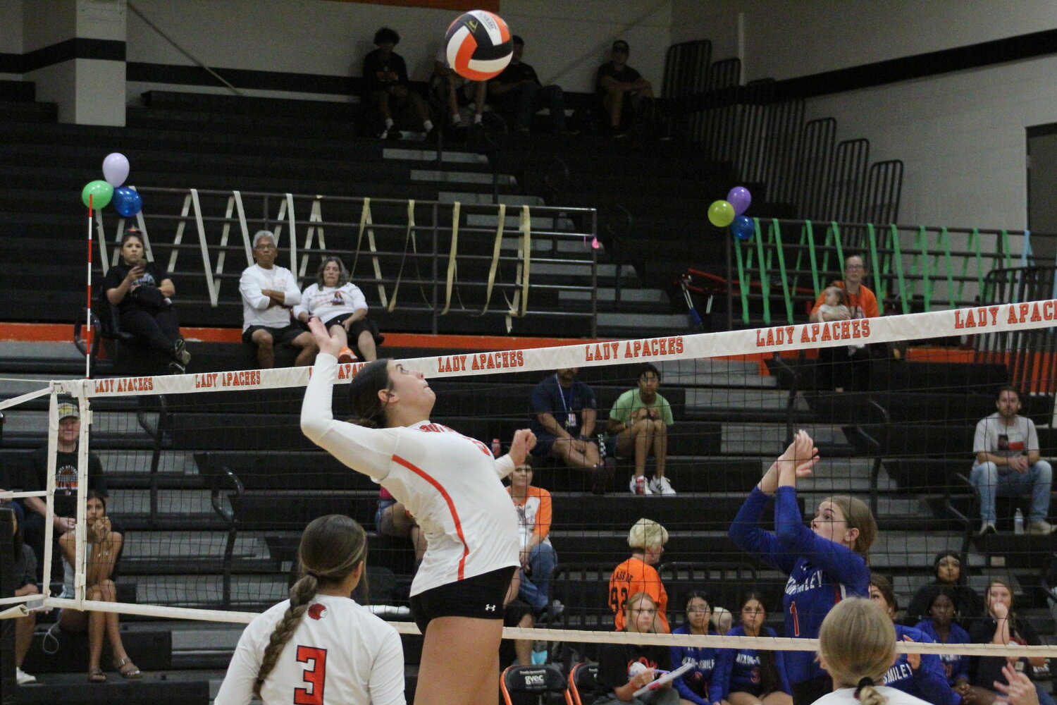 Lady Apaches middle hitter Isabella Ikard (15) jumps in the air to spike the ball against the Nixon-Smiley Lady Mustangs Friday, Sept. 13.