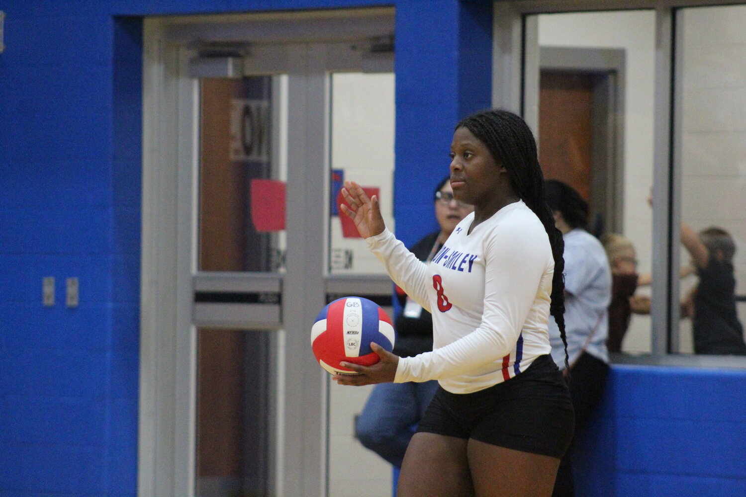 Lady Mustangs senior Janaelyn White (8) at serve for Nixon-Smiley in the non-district match against Yorktown.