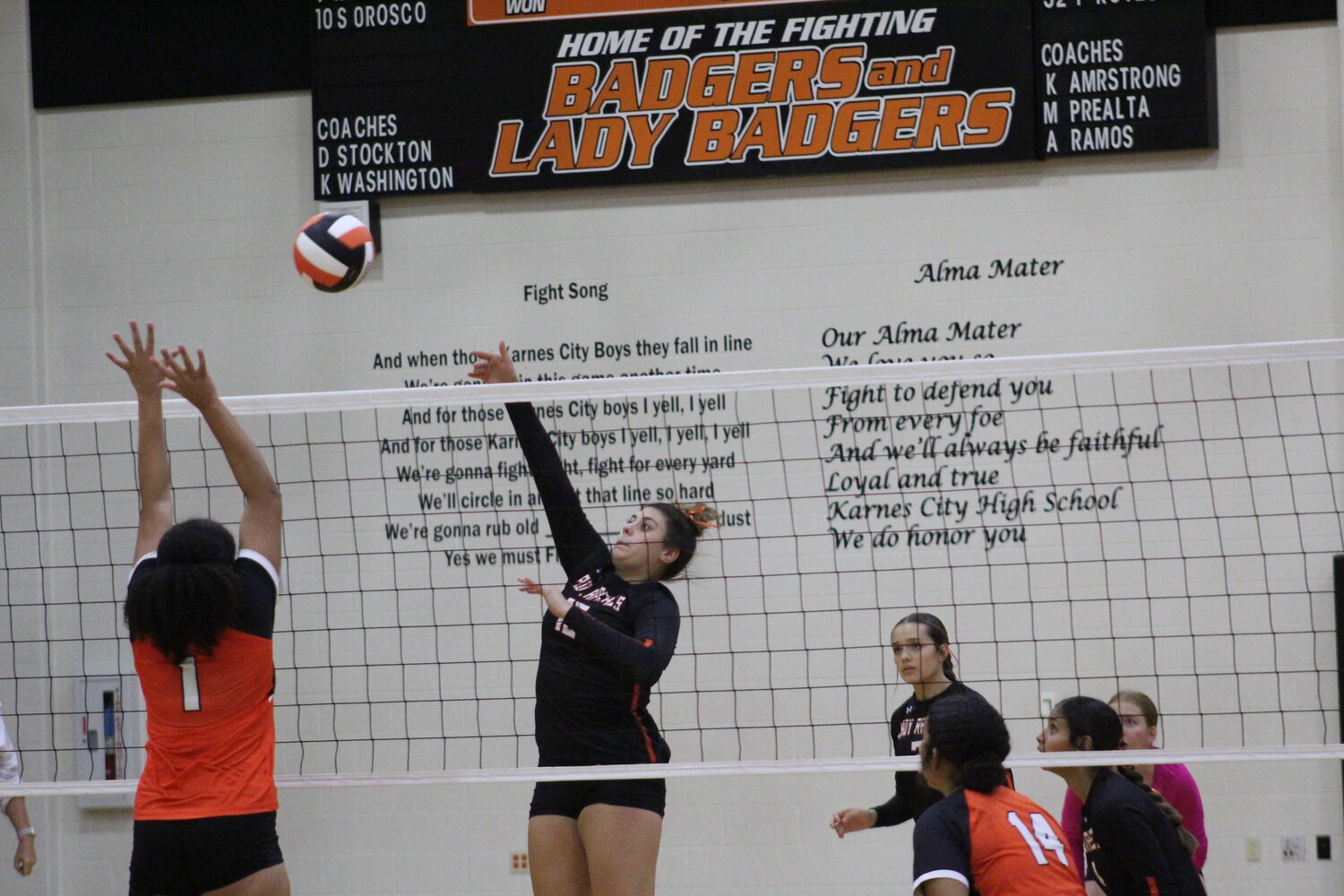 Junior middle hitter Isabela Ikard (15) spikes the ball in the air against the Lady Badgers. Ikard recorded three out of four kills in the second set against Karnes City.