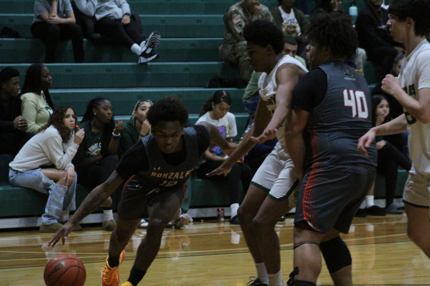 Apaches junior guard David Clack III (12) dribbles the ball by a Cole defender with teammate senior Dylan Hunt (40)  blocking. The Apaches fell to Cole, 60-29, Tuesday, Dec. 10 in San Antonio.