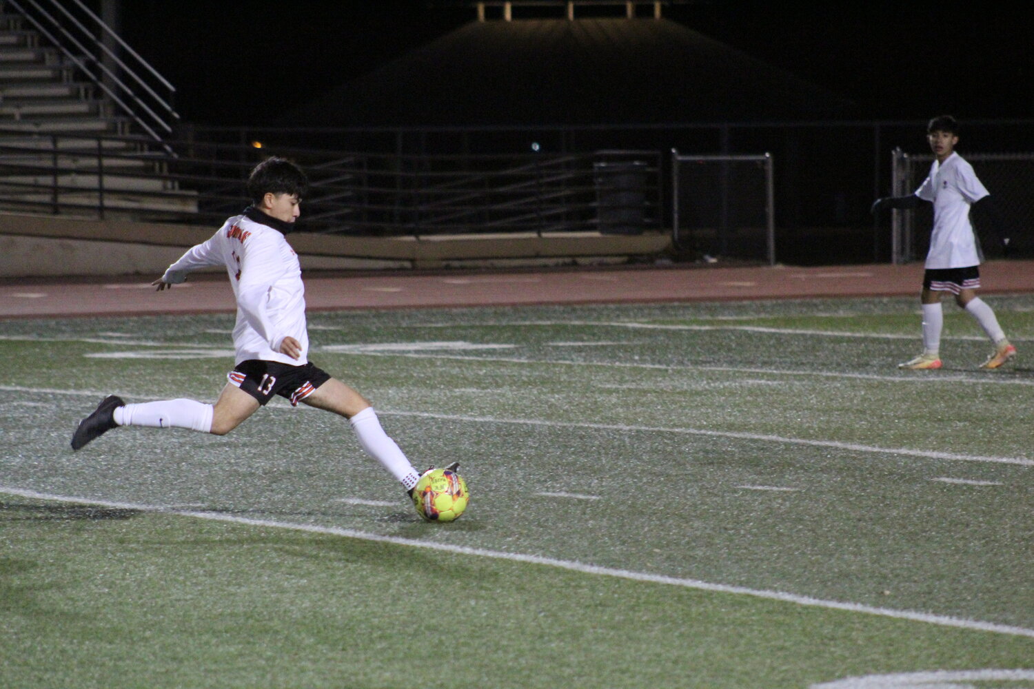Apaches sophomore Damian Orduna (13) kicks the ball towards San Antonio JFK’s goal in the district opener Friday, Jan 24.