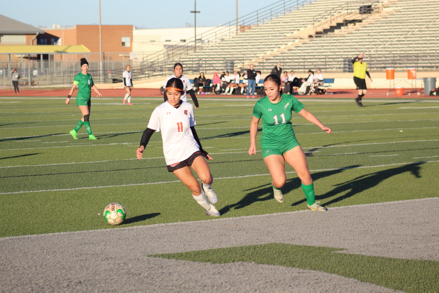 Lady Apaches Viviana Barrientos (11) and a JFK player follows the ball near the Lady Rockets’ goal in the district opener.