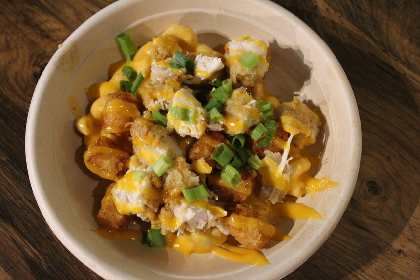 The fried chicken bowl is loaded with beer cheese mac and cheese, tots and topped with Tang aioli and green onions.