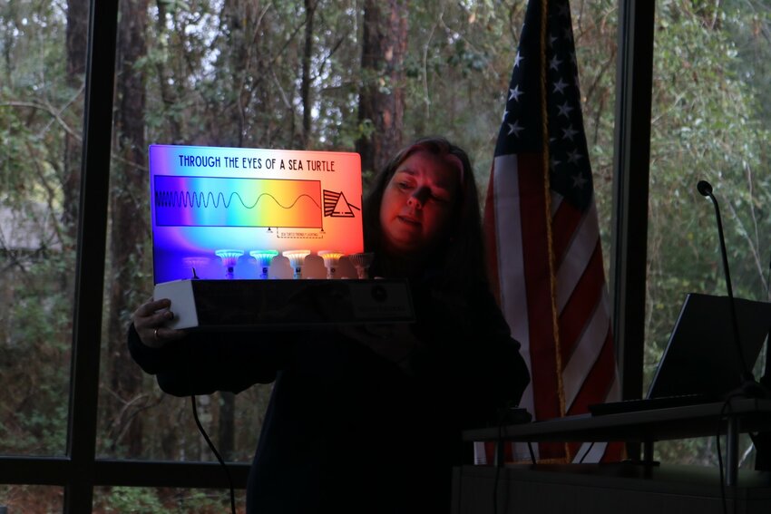 RUTH MAYO / GULF COAST MEDIA
Chandra Wright demonstrates turtle friendly lighting using a tool created by Gulf Shores City Schools where viewers can look through a film card to "see like a sea turtle."