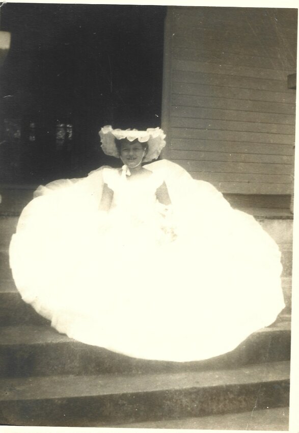 Author dressed in flower girl dress in 1954.