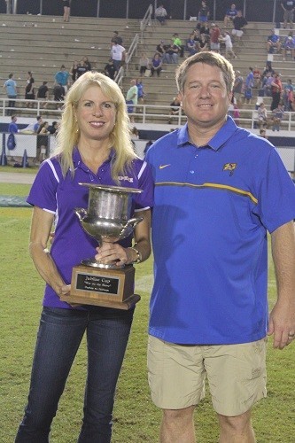 Fairhope High Principal Jon Cardwell passes the Jubilee Cup Trophy to Daphne High Principal Meredith Foster.