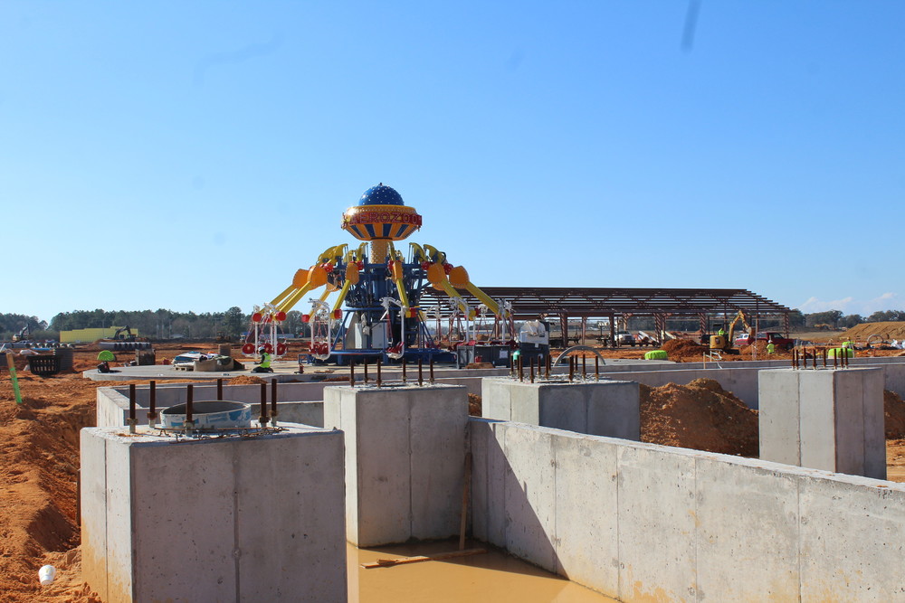 Inside theme park, facing west. The concrete slabs are the foundation for the roller coaster. The steel-framed building is the maintenance building for the park.