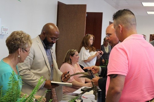 Baldwin County Sheriff Huey &ldquo;Hoss&rdquo; Mack Jr. gets a book signed by the Rev. Chette Williams Sr. at the Central Baldwin Chamber of Commerce&rsquo;s 13th annual Prayer Breakfast at the Baldwin EMC Training Center in Summerdale.